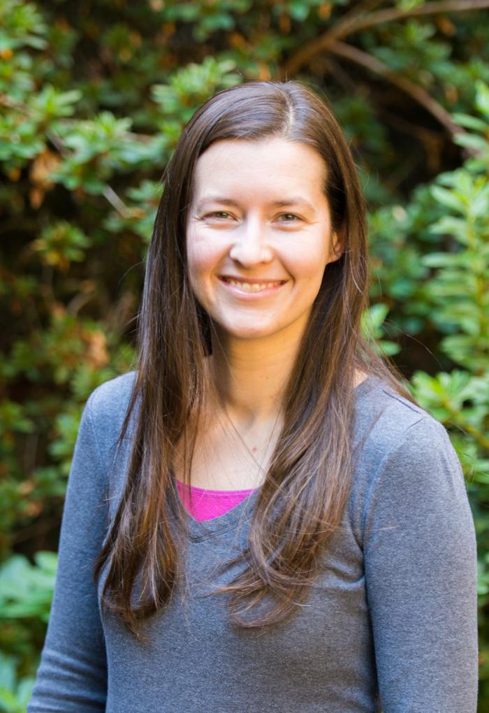 Stephanie Bollman stands outside in front of trees